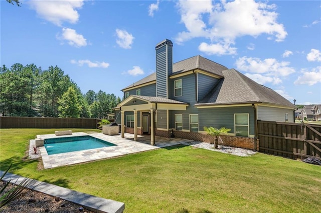 back of house featuring a yard, a fenced in pool, and a patio area