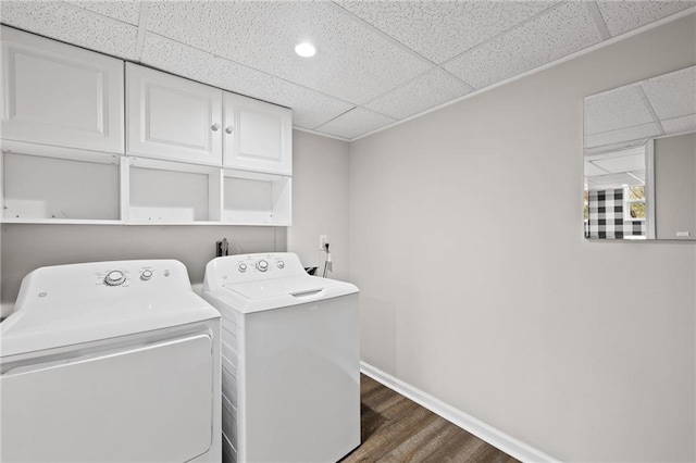 laundry area featuring dark hardwood / wood-style floors, cabinets, and washing machine and clothes dryer