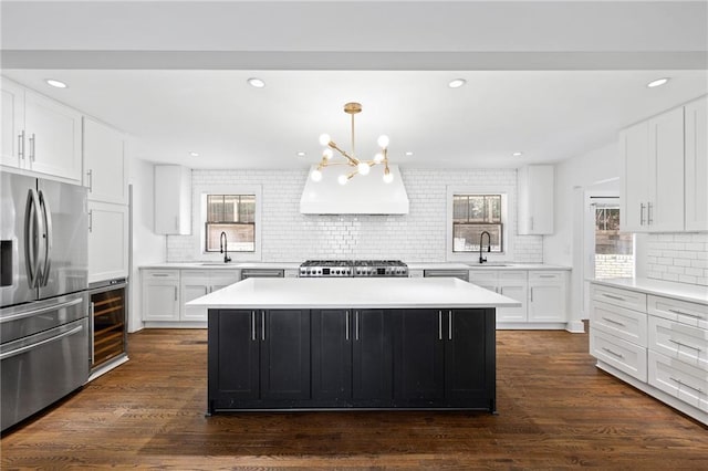 kitchen with white cabinetry, a kitchen island, beverage cooler, and stainless steel fridge with ice dispenser