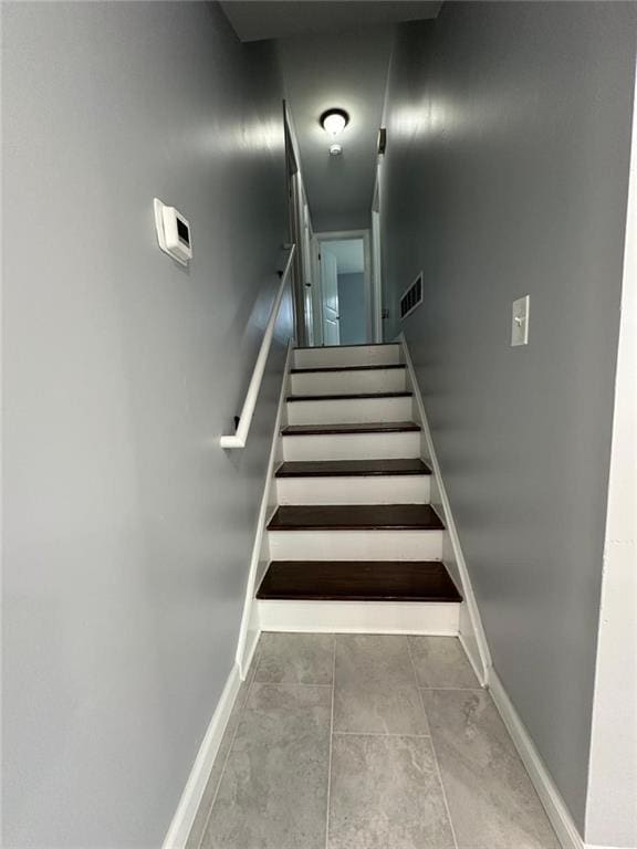 staircase with visible vents and baseboards