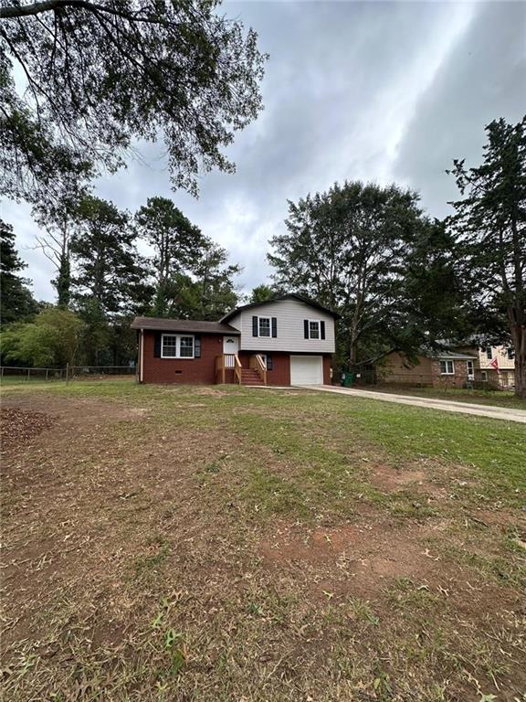split level home with driveway, a front yard, and a garage