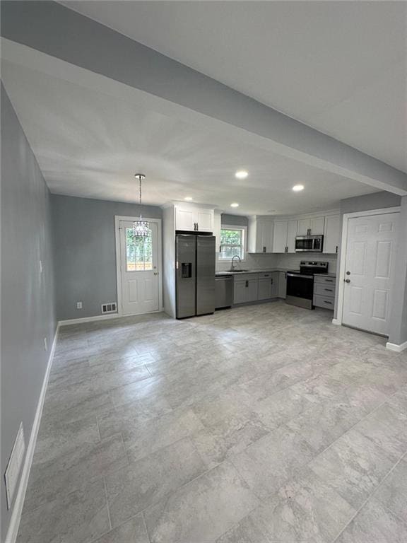 kitchen with a sink, plenty of natural light, visible vents, baseboards, and appliances with stainless steel finishes