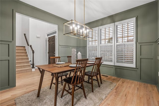 dining room with ornamental molding, a chandelier, and light wood-type flooring