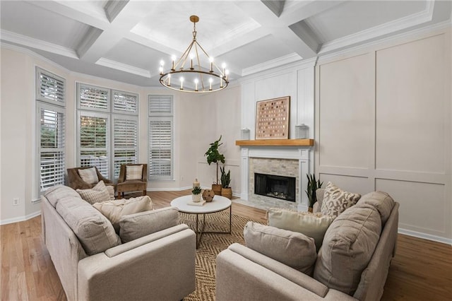 living room with beam ceiling, a notable chandelier, a large fireplace, coffered ceiling, and light hardwood / wood-style floors