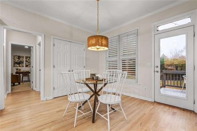 dining space featuring light hardwood / wood-style floors and ornamental molding