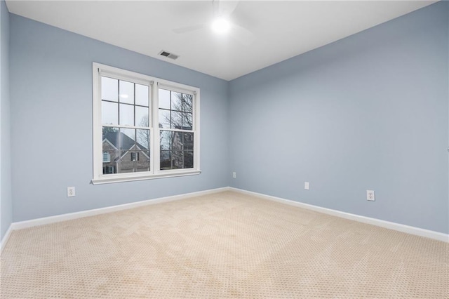 carpeted spare room featuring ceiling fan