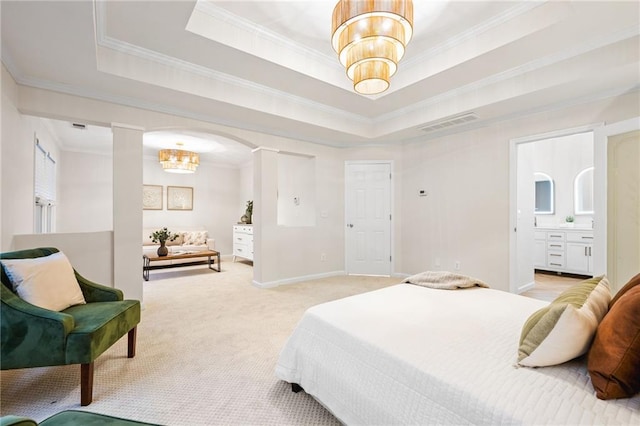 bedroom with crown molding, light colored carpet, ensuite bath, and a tray ceiling