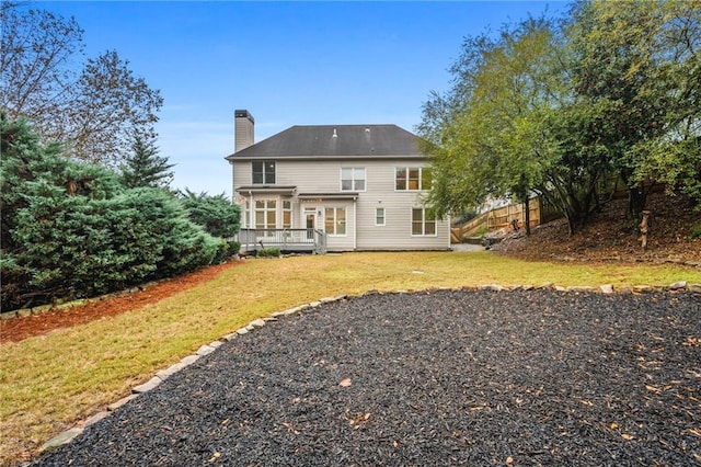 back of house featuring a deck and a yard