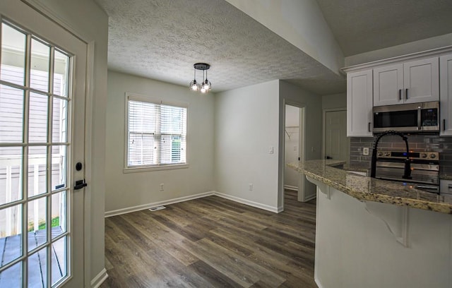 515 Allens Landing Ct, Lawrenceville, GA 30045 - kitchen featuring appliances with stainless steel finishes, backsplash, baseboards, dark wood-style floors, and stone countertops