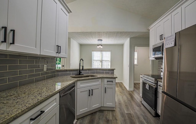 515 Allens Landing Ct, Lawrenceville, GA 30045 - kitchen with stainless steel appliances, a sink, a peninsula, tasteful backsplash, and dark wood finished floors