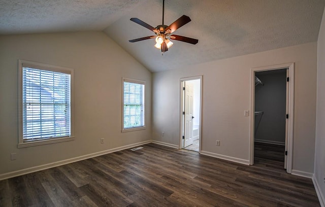 515 Allens Landing Ct, Lawrenceville, GA 30045 - unfurnished bedroom with dark wood finished floors, a spacious closet, a textured ceiling, lofted ceiling, and baseboards
