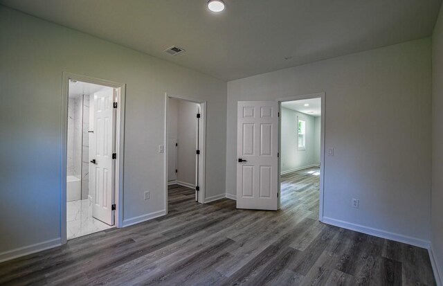 515 Allens Landing Ct, Lawrenceville, GA 30045 - unfurnished bedroom with wood finished floors, baseboards, and connected bathroom