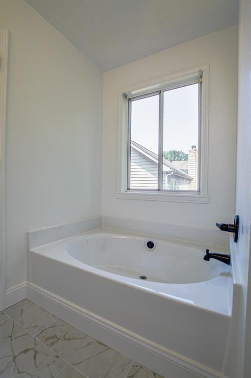 515 Allens Landing Ct, Lawrenceville, GA 30045 - bathroom with marble look tiles, a bath, and baseboards