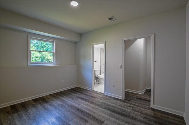 515 Allens Landing Ct, Lawrenceville, GA 30045 - unfurnished bedroom with dark wood finished floors, baseboards, ensuite bath, and a walk in closet
