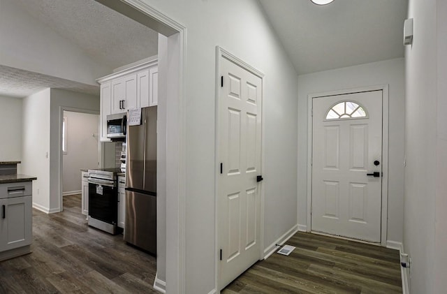 515 Allens Landing Ct, Lawrenceville, GA 30045 - doorway with dark wood-type flooring, baseboards, vaulted ceiling, and a textured ceiling