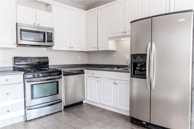 kitchen featuring sink, light tile patterned floors, white cabinets, and appliances with stainless steel finishes