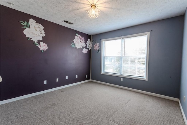 unfurnished room featuring a textured ceiling and carpet