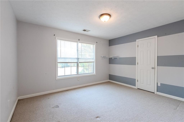 carpeted spare room with a textured ceiling