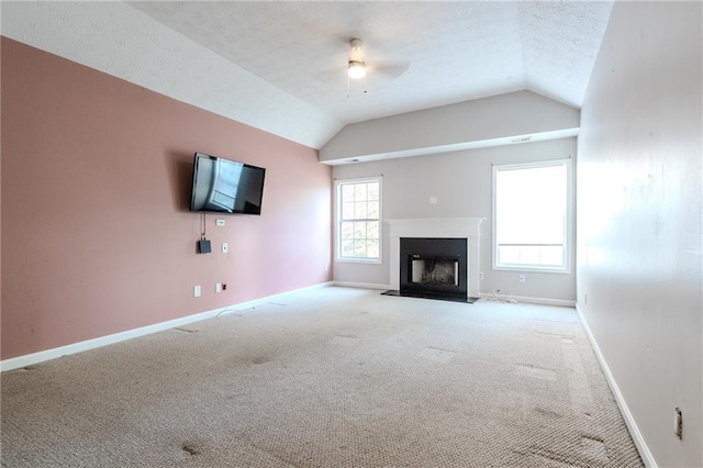 unfurnished living room featuring lofted ceiling, carpet flooring, a textured ceiling, and ceiling fan