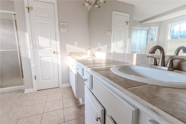 bathroom featuring vanity, a shower with door, and tile patterned flooring