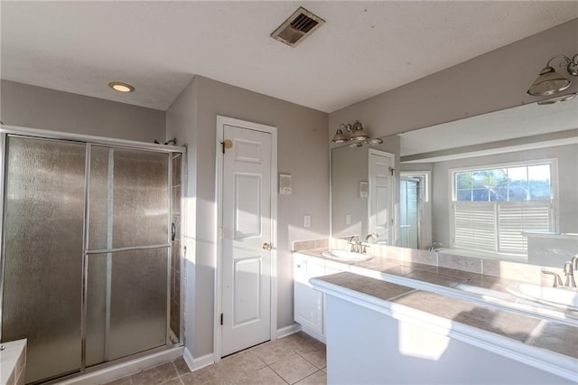 bathroom featuring vanity, a shower with shower door, and tile patterned floors