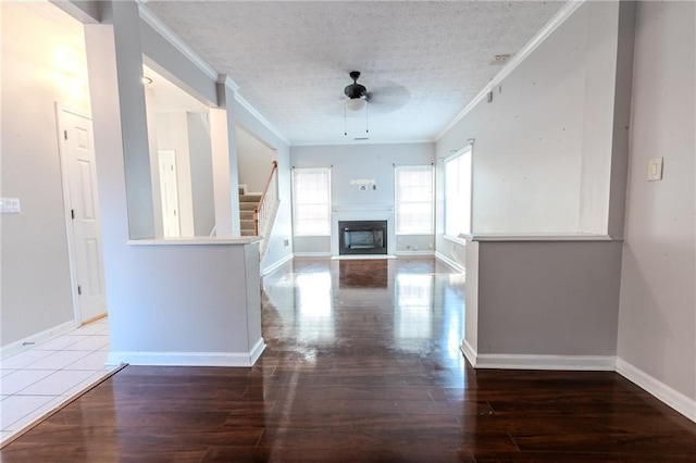 corridor with hardwood / wood-style flooring, ornamental molding, and a textured ceiling