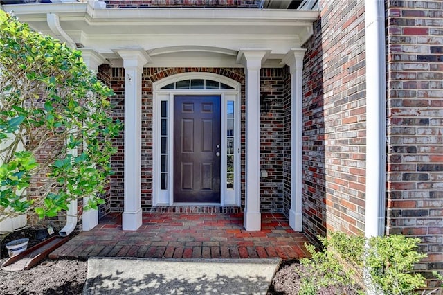 property entrance featuring brick siding