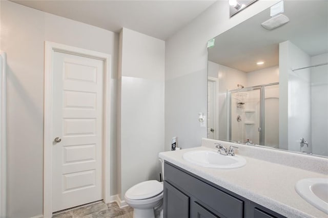 full bath with double vanity, a stall shower, toilet, and a sink