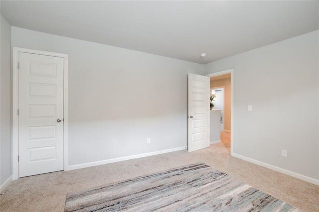 carpeted spare room featuring baseboards