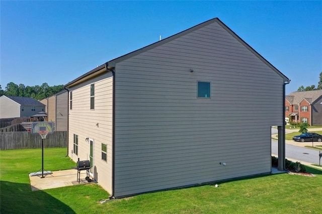 view of home's exterior with a patio, a lawn, and fence