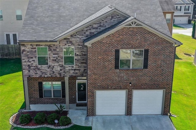 traditional-style home featuring a garage, a front yard, stone siding, and driveway