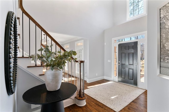 entryway featuring stairs, a high ceiling, wood finished floors, and baseboards