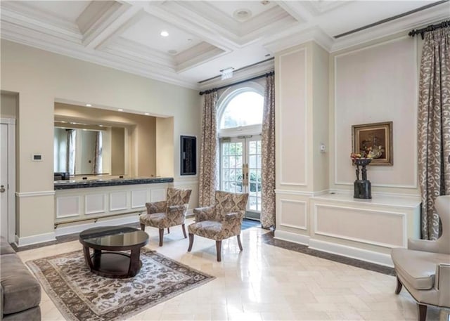 sitting room featuring beam ceiling, a towering ceiling, coffered ceiling, ornamental molding, and french doors