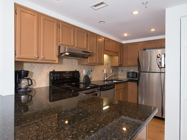 kitchen featuring tasteful backsplash, sink, dark stone counters, kitchen peninsula, and stainless steel appliances