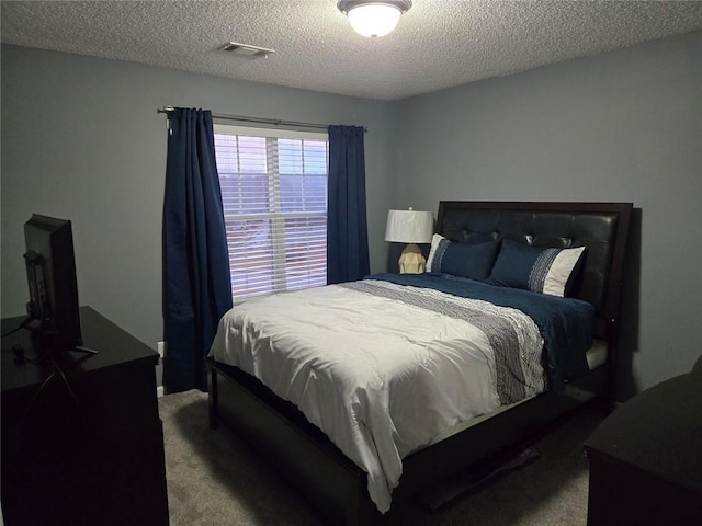 bedroom featuring carpet flooring and a textured ceiling