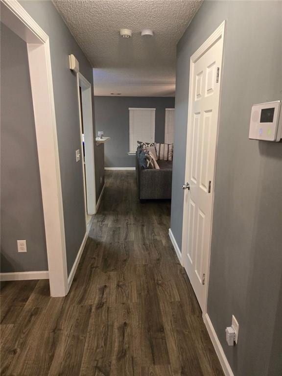 hallway featuring dark hardwood / wood-style floors and a textured ceiling