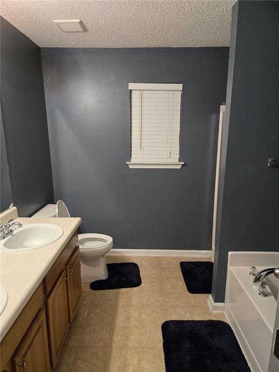 bathroom with a tub to relax in, toilet, a textured ceiling, vanity, and tile patterned flooring