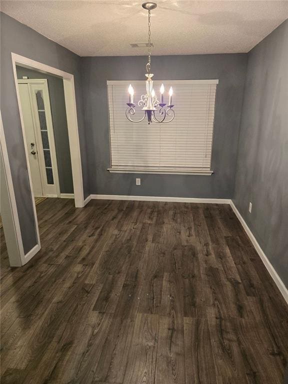 unfurnished dining area with a notable chandelier and dark hardwood / wood-style flooring