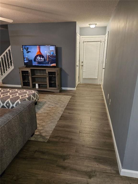 living room with dark hardwood / wood-style flooring and a textured ceiling