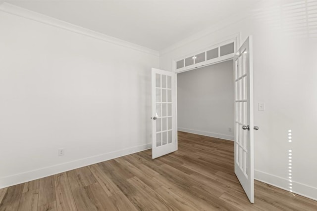 unfurnished room featuring crown molding, wood-type flooring, and french doors