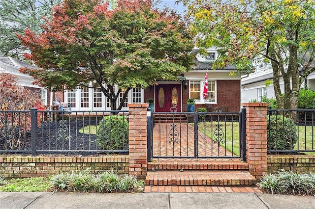 obstructed view of property featuring a fenced front yard and brick siding