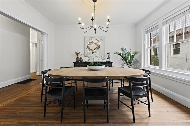 dining room with baseboards, wood finished floors, and crown molding