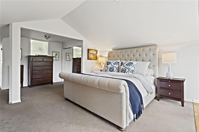 bedroom with lofted ceiling, light colored carpet, and baseboards