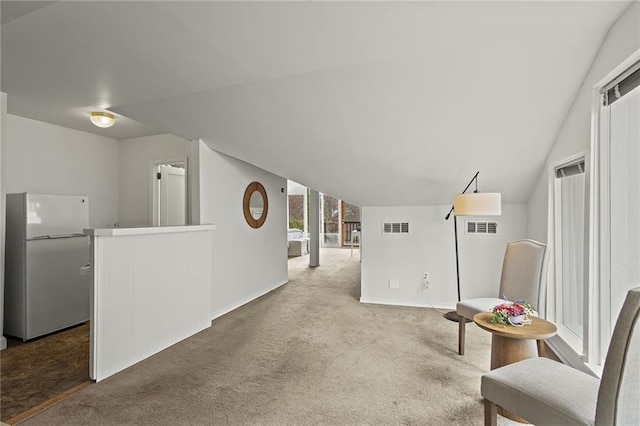 sitting room featuring vaulted ceiling, carpet, visible vents, and baseboards