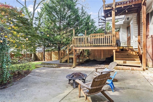 view of patio featuring a deck, stairway, fence, and a fire pit