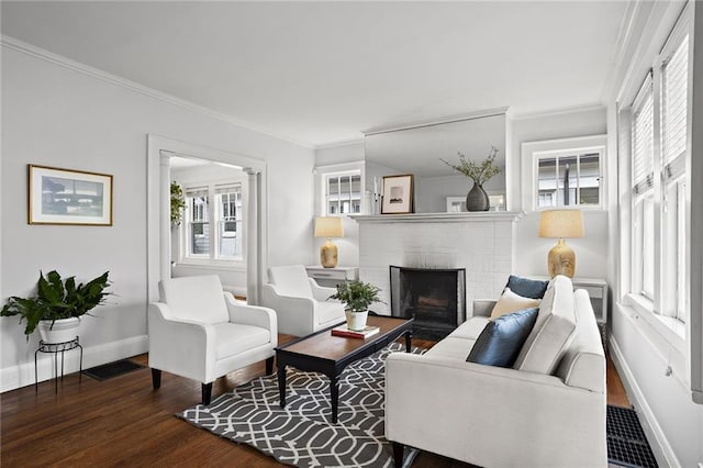 living room with a fireplace, crown molding, baseboards, and wood finished floors