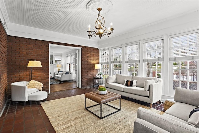 living area with a chandelier and brick wall