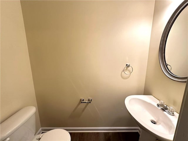 bathroom with hardwood / wood-style floors, toilet, and sink