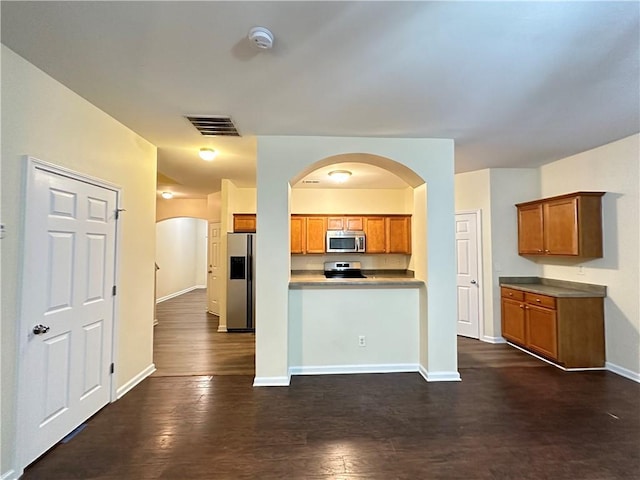 kitchen featuring stainless steel appliances and dark hardwood / wood-style floors