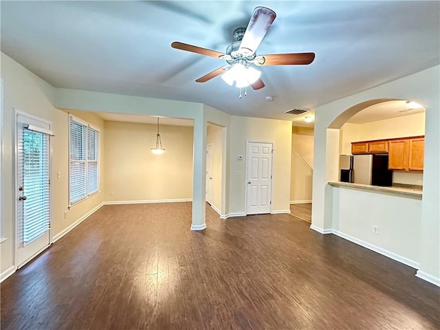 unfurnished living room featuring ceiling fan and dark hardwood / wood-style floors